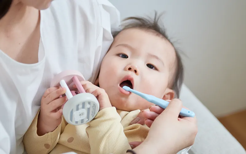 最初の白い歯が生えて笑顔を見せる赤ちゃんのイメージ